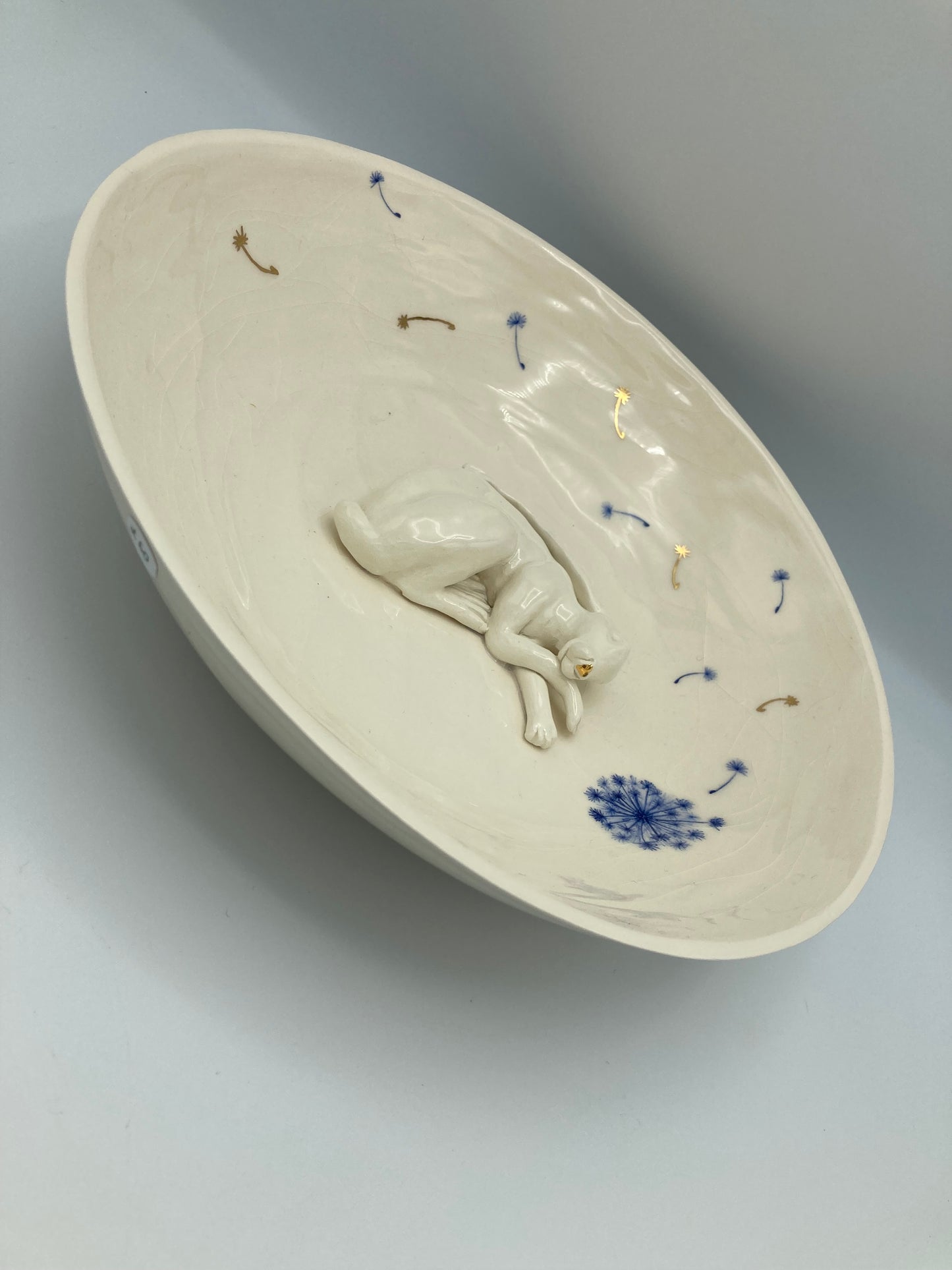 Large sleeping hare bowl with blue and gold dandelions