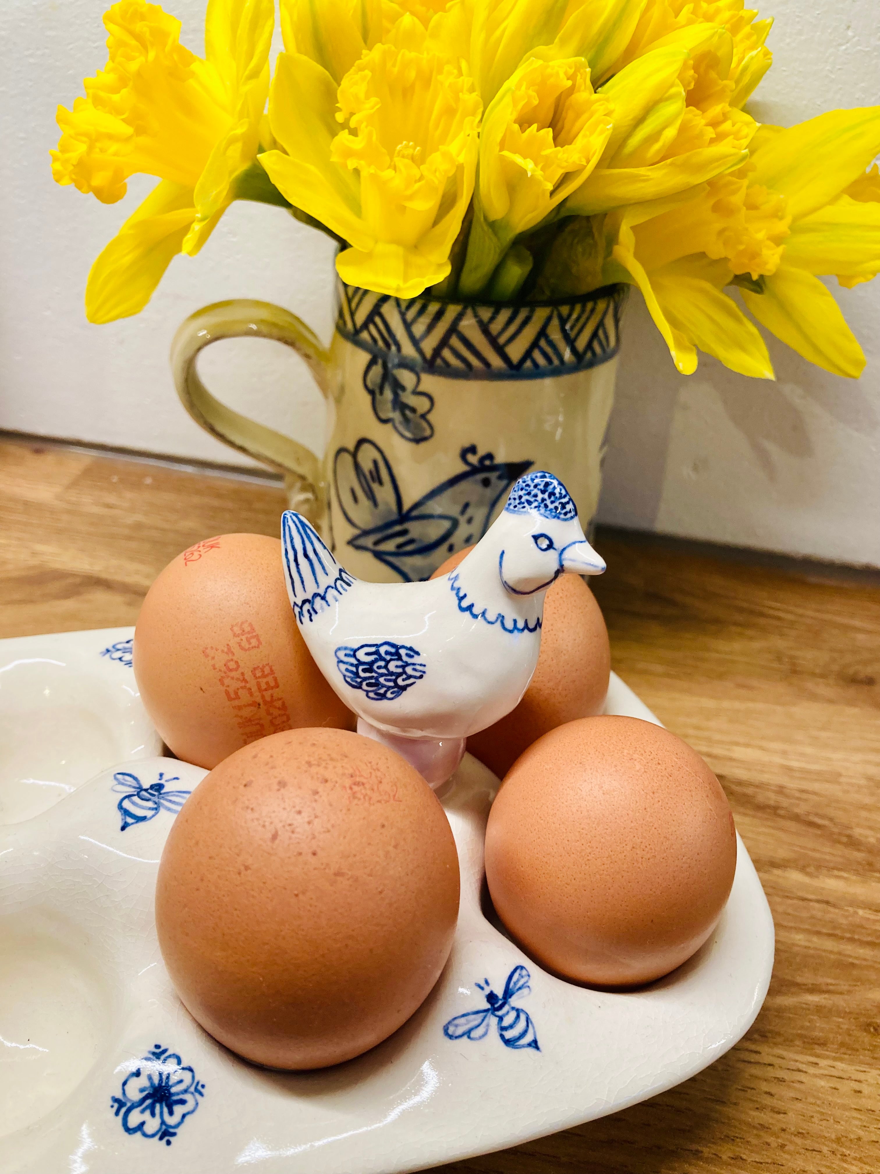 Handmade ceramic egg tray with figurine of chickens. 10 eggs tray made if white ceramic and decorated with delicate designs of bees and flowers in navy blue colour