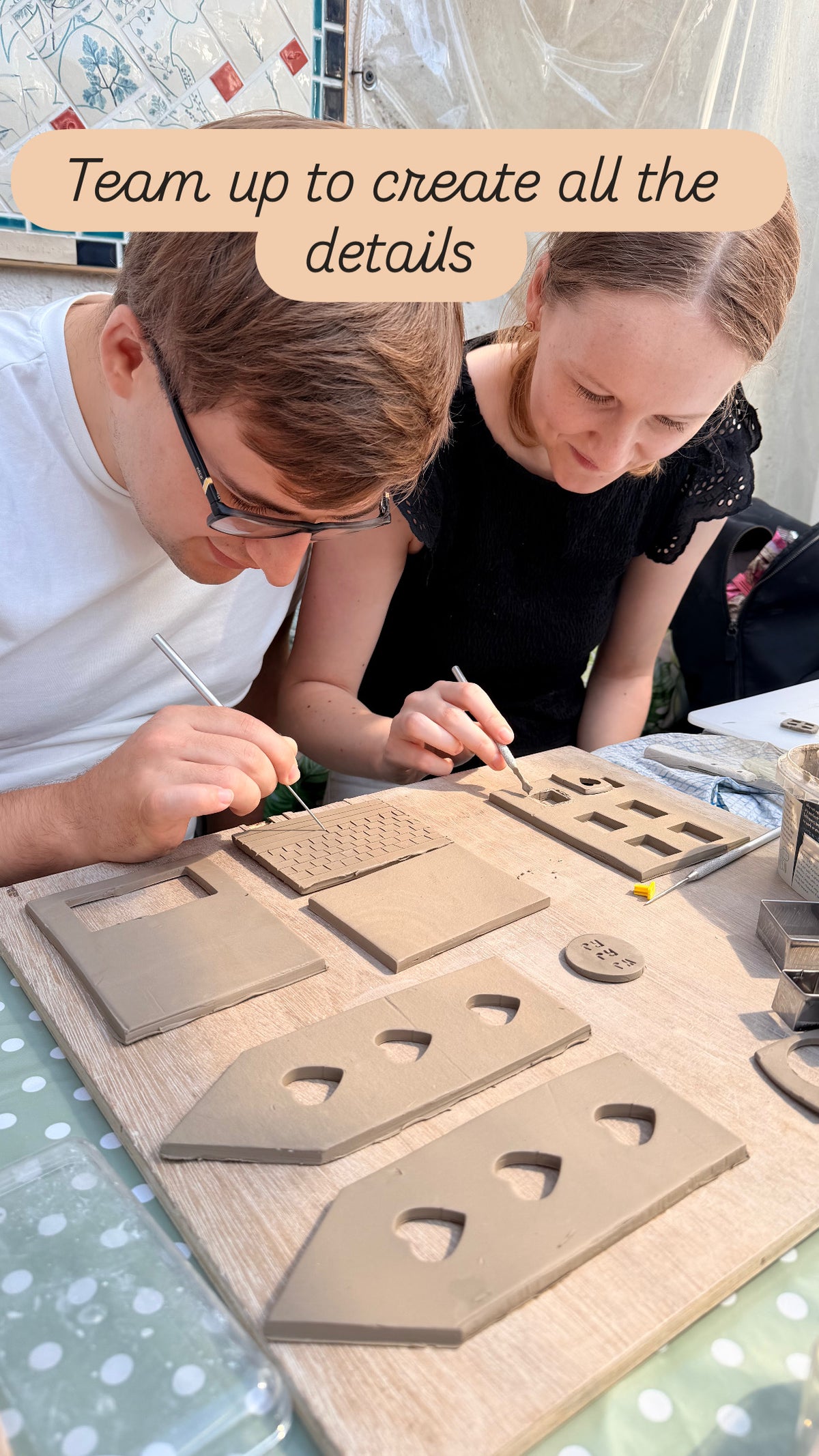 A young couple are adding the details to the walls and roof of their ceramic house, working together to create an accurate portrait of their own house