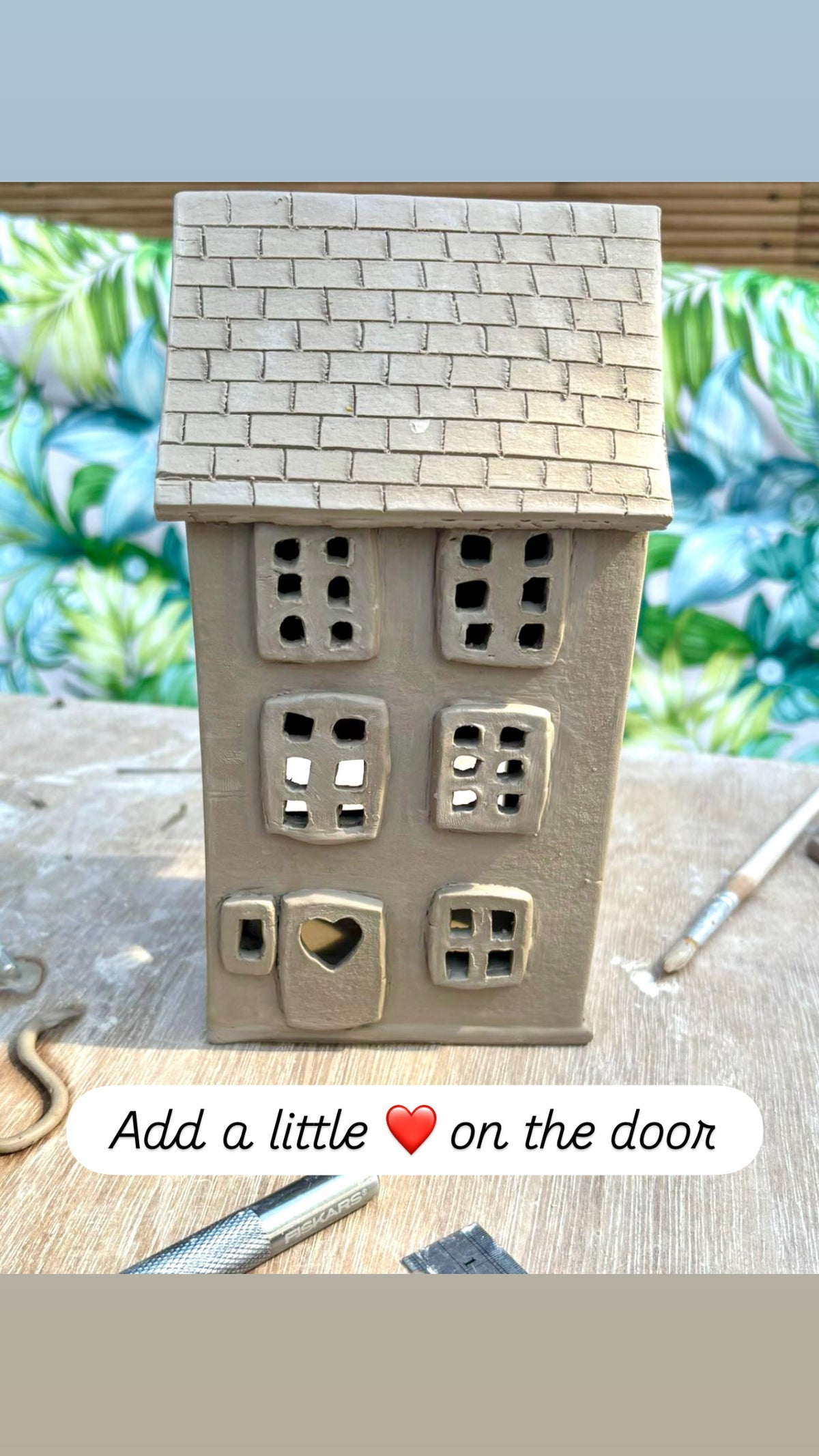 A picture of a ceramic three storey town house with a little heart on the door